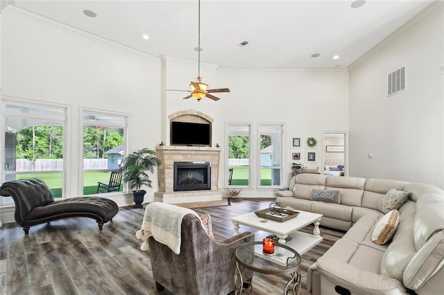 30222 N Dixie Ranch Rd, Lacombe, LA 70445 - living area featuring a high ceiling, ornamental molding, a glass covered fireplace, wood finished floors, and a ceiling fan