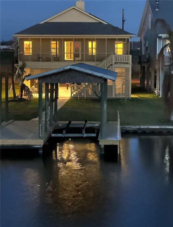 back of property with boat lift and a water view