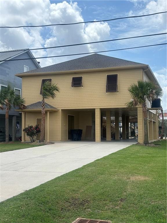 view of front facade featuring a carport, concrete driveway, and a front yard
