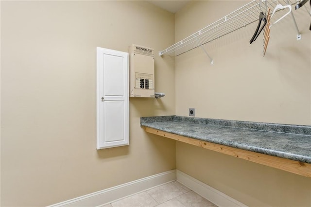 clothes washing area with light tile patterned floors, hookup for an electric dryer, and baseboards