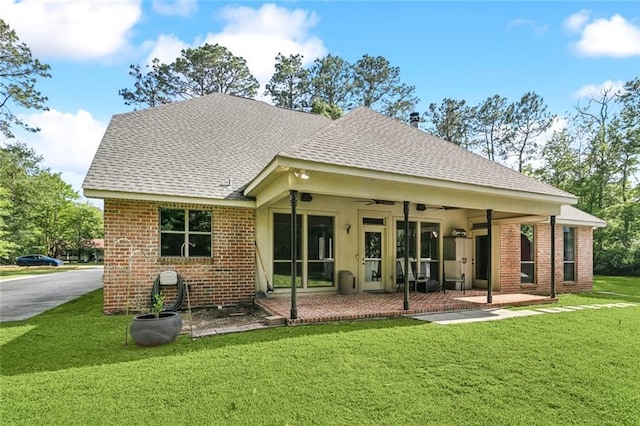 back of house featuring ceiling fan, a patio, brick siding, a shingled roof, and a yard