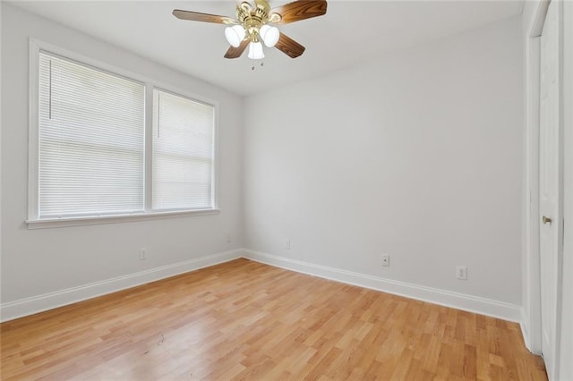 spare room featuring a ceiling fan, baseboards, and light wood-type flooring