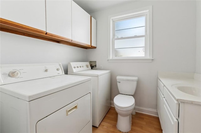 bathroom featuring wood finished floors, baseboards, vanity, toilet, and washer and clothes dryer