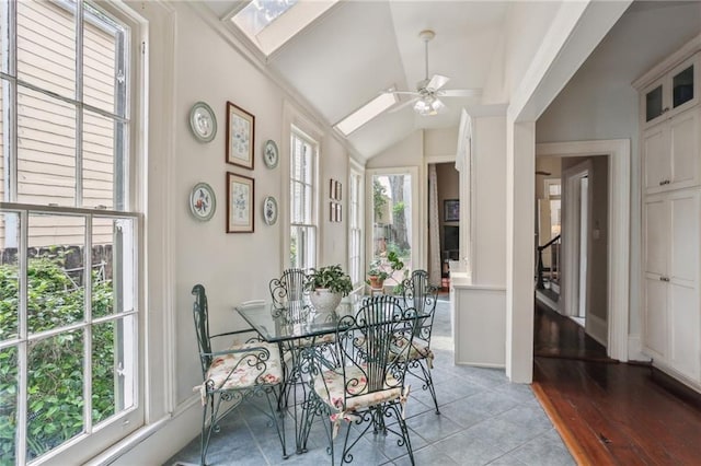 dining room with lofted ceiling with skylight and ceiling fan