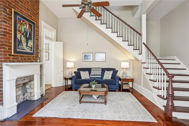 living area with ceiling fan, stairs, and wood finished floors