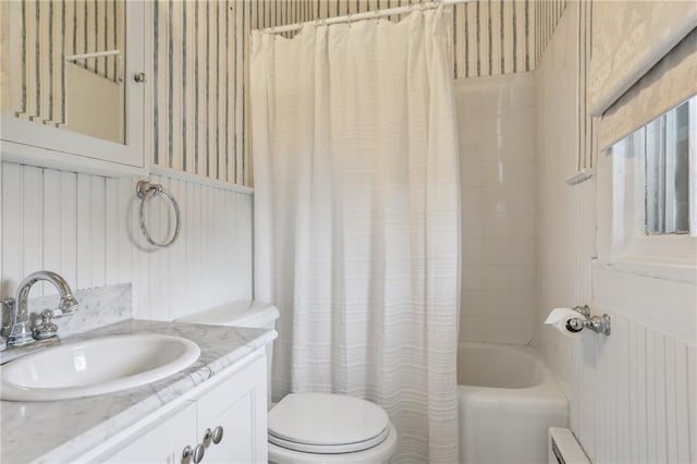 bathroom featuring toilet, shower / bath combination with curtain, and vanity