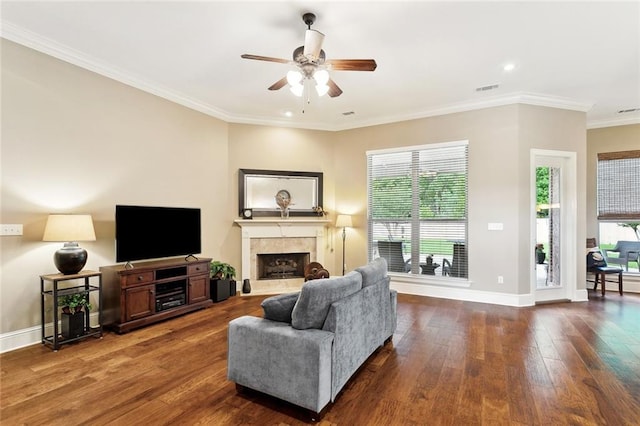 living area featuring baseboards, ceiling fan, dark wood-style floors, and a tile fireplace