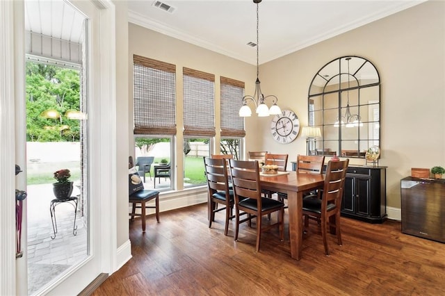 dining space featuring visible vents, baseboards, a chandelier, ornamental molding, and dark wood-type flooring