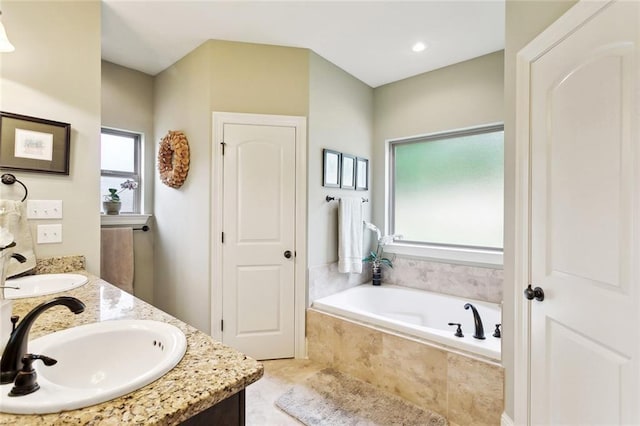 bathroom featuring double vanity, a sink, and a bath