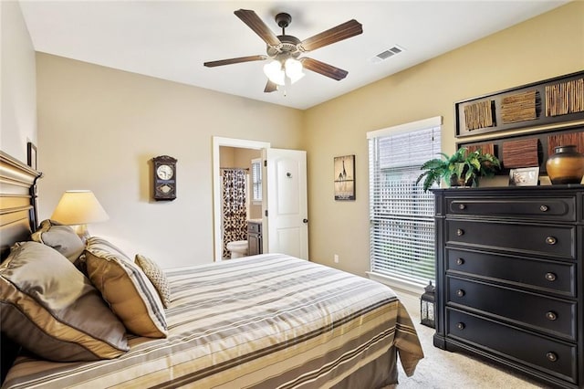 bedroom with visible vents, connected bathroom, ceiling fan, and light carpet