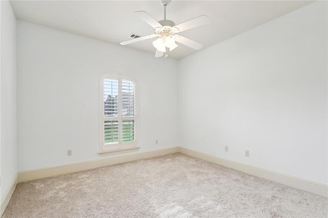 carpeted empty room with baseboards, ceiling fan, and visible vents