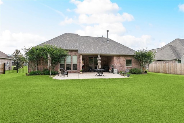 rear view of property featuring a fenced backyard, a yard, a patio area, and brick siding