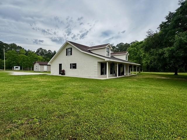 rear view of house featuring a yard