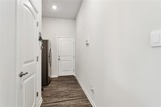 corridor featuring baseboards and dark wood finished floors