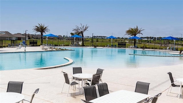 pool featuring fence and a patio