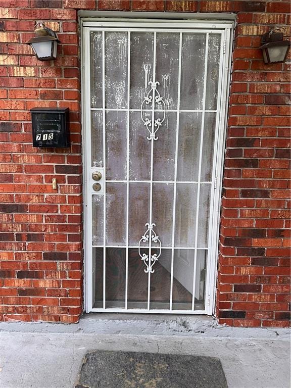 entrance to property featuring brick siding
