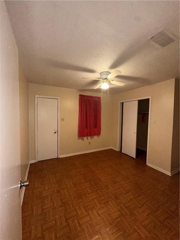unfurnished room featuring a ceiling fan, a textured ceiling, visible vents, and baseboards