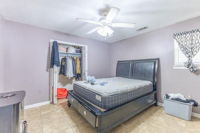 bedroom featuring a closet, visible vents, baseboards, a ceiling fan, and light tile patterned floors