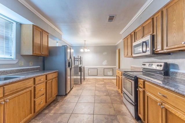 kitchen featuring crown molding, brown cabinetry, visible vents, appliances with stainless steel finishes, and a notable chandelier