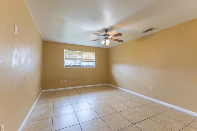 empty room featuring baseboards, ceiling fan, visible vents, and light tile patterned floors