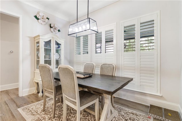 dining area featuring an inviting chandelier, baseboards, and light wood finished floors