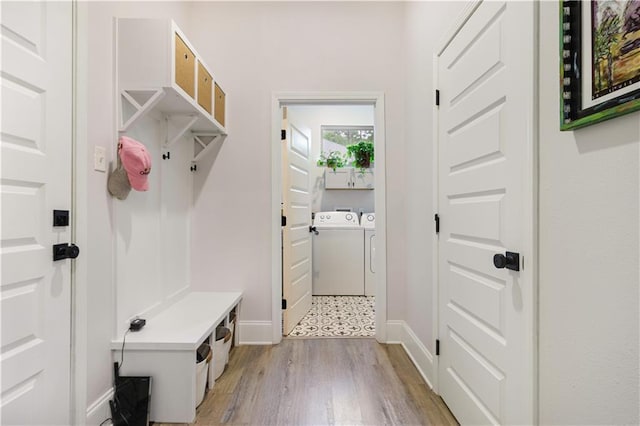 mudroom with separate washer and dryer, baseboards, and light wood-type flooring