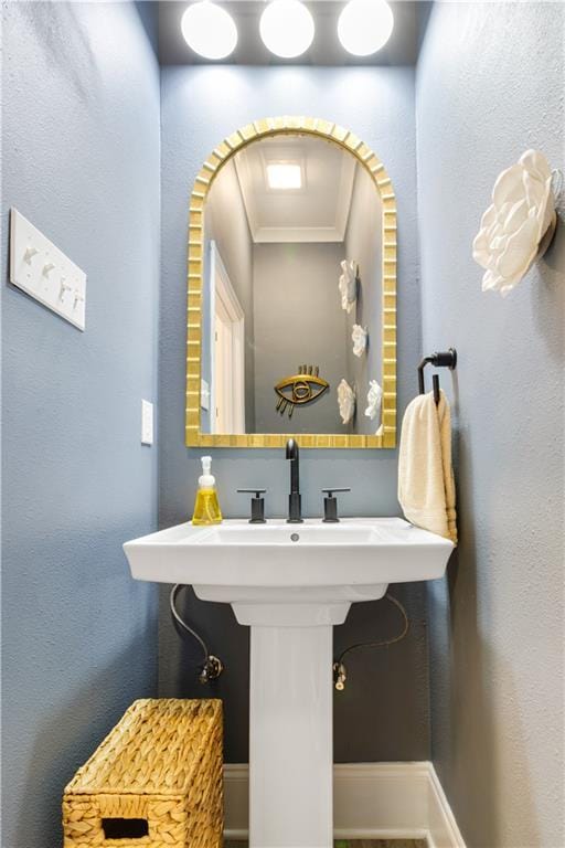 bathroom with baseboards and ornamental molding