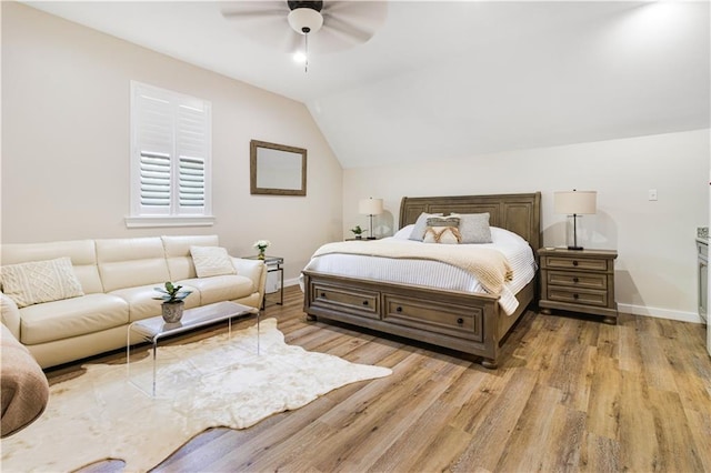 bedroom featuring baseboards, light wood finished floors, and lofted ceiling
