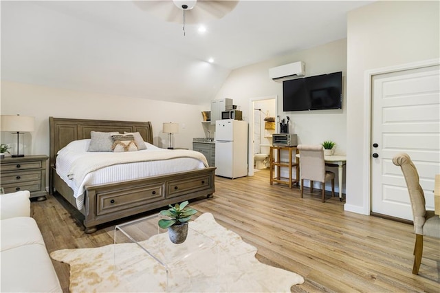 bedroom with freestanding refrigerator, an AC wall unit, vaulted ceiling, and light wood finished floors
