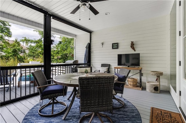 wooden terrace with a ceiling fan and outdoor dining space