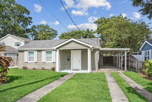 view of front facade with fence, driveway, roof with shingles, and a carport