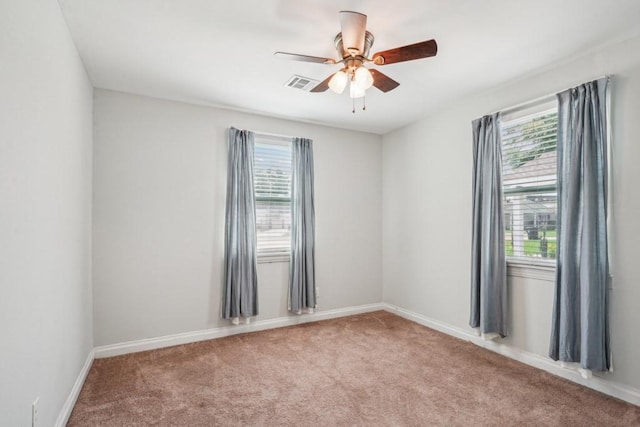 empty room with a ceiling fan, baseboards, visible vents, and carpet