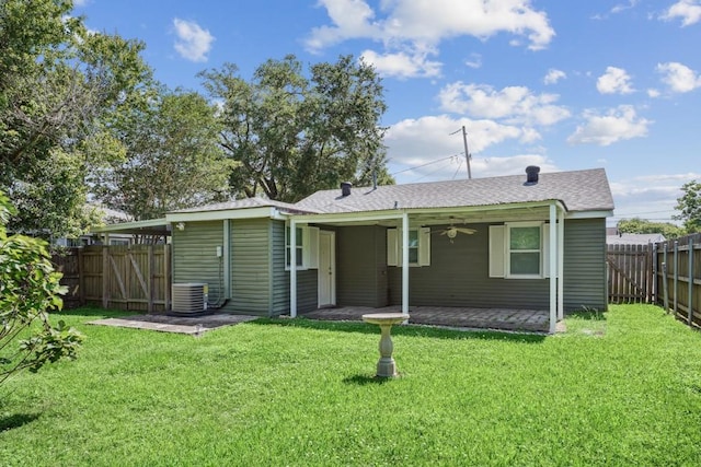 view of front of house featuring ceiling fan, a front yard, a fenced backyard, a shingled roof, and a patio area