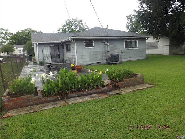 rear view of property featuring cooling unit and roof with shingles