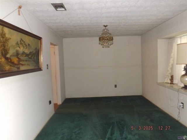 unfurnished room with carpet flooring, a chandelier, and a textured ceiling