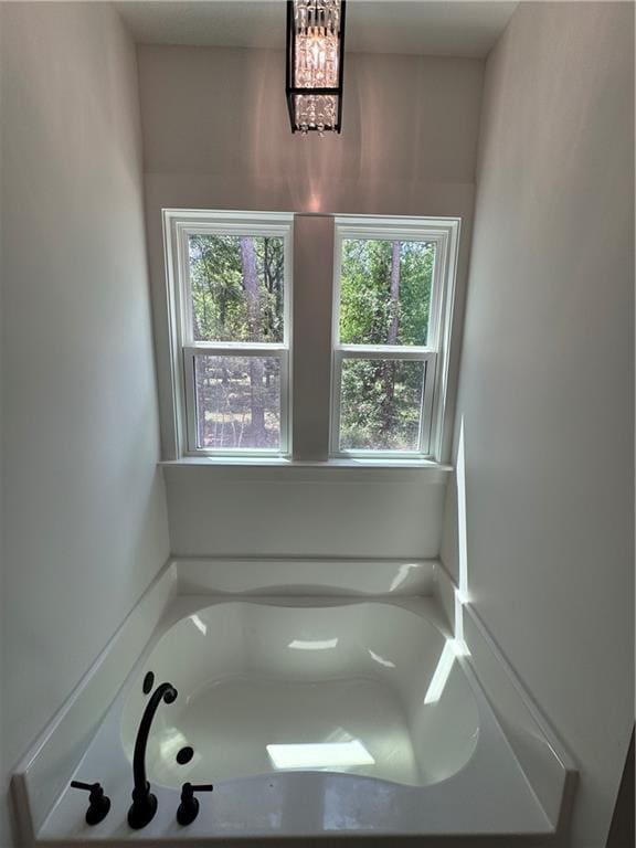 bathroom with a garden tub and a healthy amount of sunlight