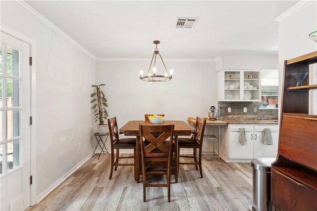 7020 Wilty St, Metairie, LA 70003 - dining room with a chandelier, light wood finished floors, and ornamental molding