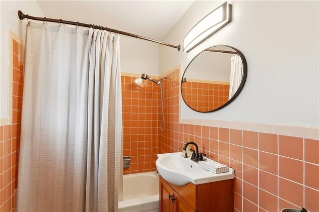 7020 Wilty St, Metairie, LA 70003 - bathroom featuring vanity, shower / tub combo with curtain, tile walls, and decorative backsplash
