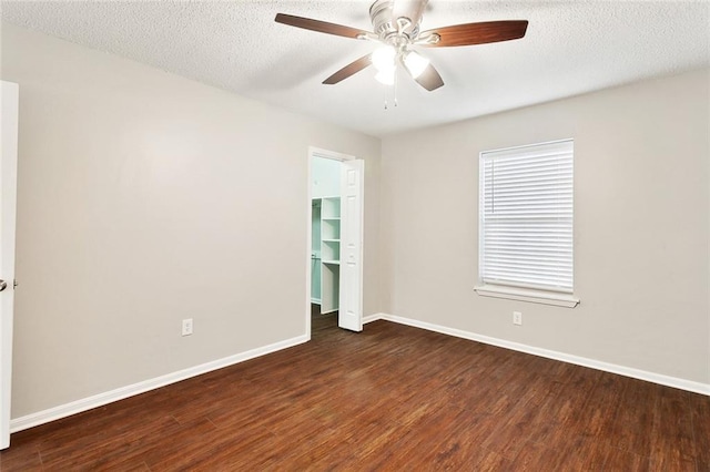 unfurnished room featuring a textured ceiling, baseboards, a ceiling fan, and wood finished floors