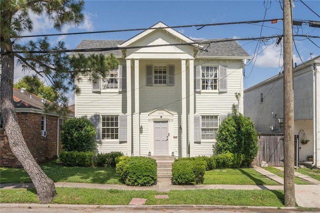 3408 Nashville Ave, New Orleans, LA 70125 - neoclassical home featuring roof with shingles, fence, and a front yard