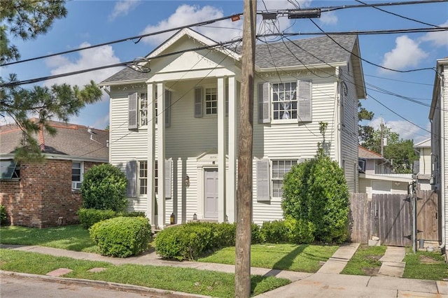 3408 Nashville Ave, New Orleans, LA 70125 - neoclassical / greek revival house with fence, a gate, roof with shingles, and a front lawn