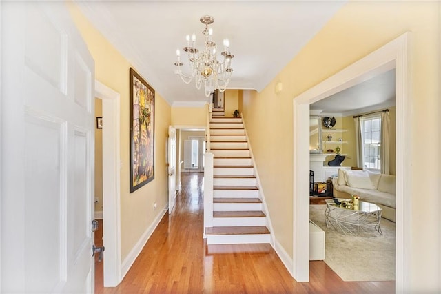 3408 Nashville Ave, New Orleans, LA 70125 - staircase with baseboards, ornamental molding, wood finished floors, and a notable chandelier