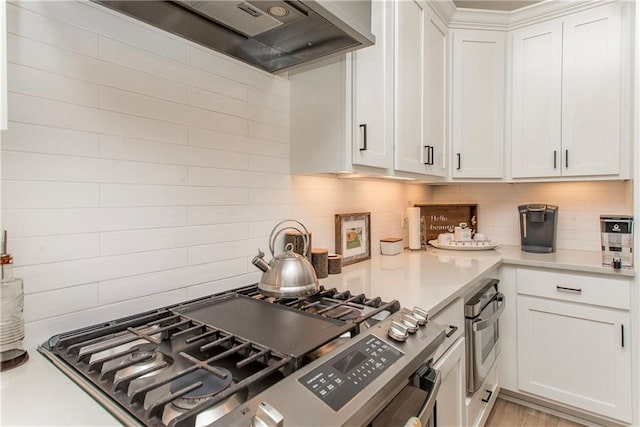 kitchen featuring oven, light countertops, white cabinetry, decorative backsplash, and custom exhaust hood