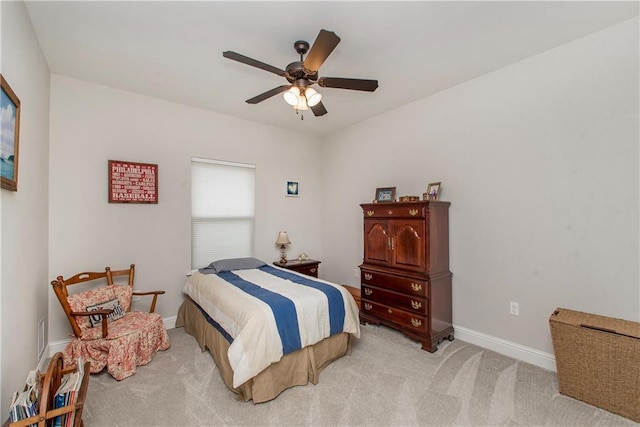 bedroom featuring light colored carpet, baseboards, and ceiling fan