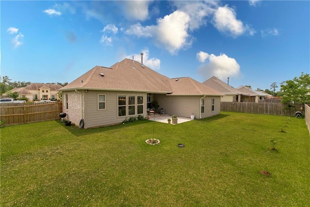 rear view of property with a patio, a fenced backyard, and a lawn