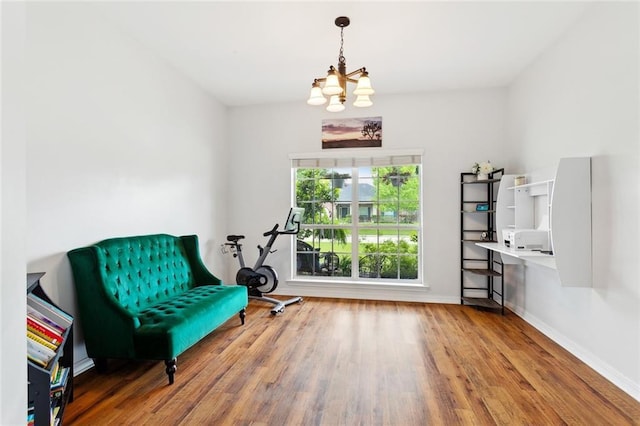sitting room with a chandelier, wood finished floors, and baseboards