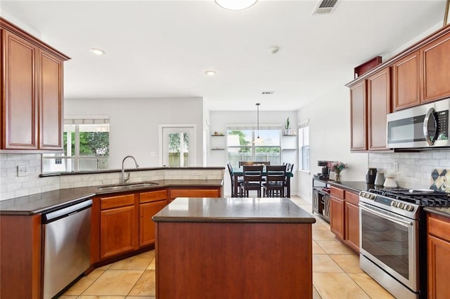 233 Arian Ln, Covington, LA 70433 - kitchen featuring appliances with stainless steel finishes, light tile patterned floors, backsplash, a peninsula, and recessed lighting