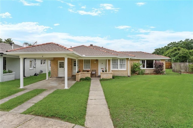 view of front facade with a porch, fence, a front lawn, and brick siding