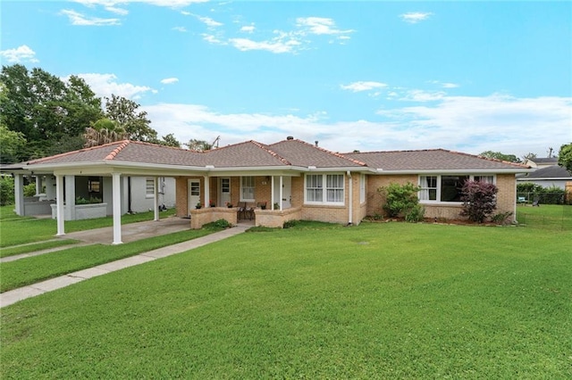 single story home with an attached carport, a front lawn, a porch, driveway, and brick siding