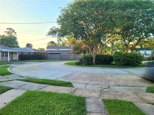 yard at dusk featuring fence